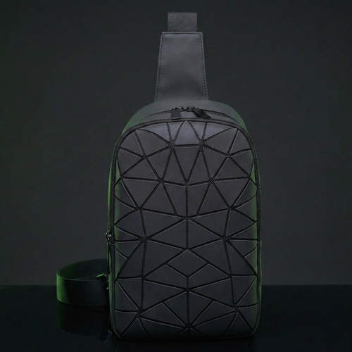 Green geometric-patterned sling bag on a dark background